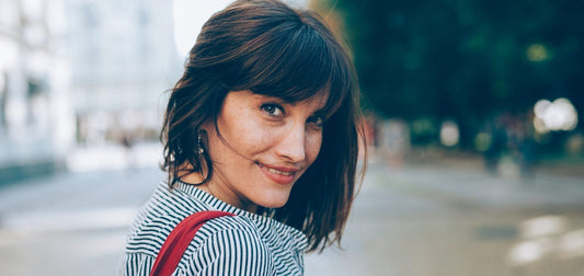 woman smiling sporting medium bang hairstyle