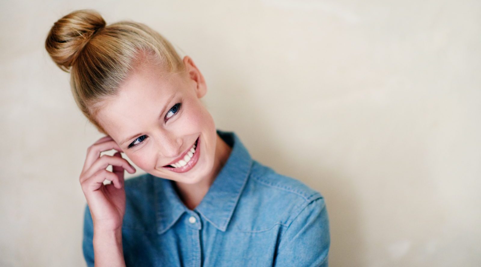 woman smiling sporting a updos hairstyle