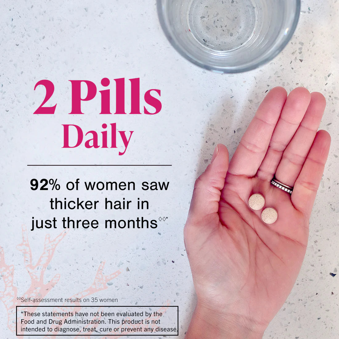 a hand holding two Viviscal hair growth supplement pills
